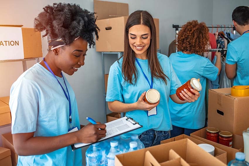 adolescentes con camisas azules y como voluntarios en una despensa de alimentos