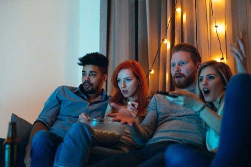 2 couples sitting on couch watching a movie